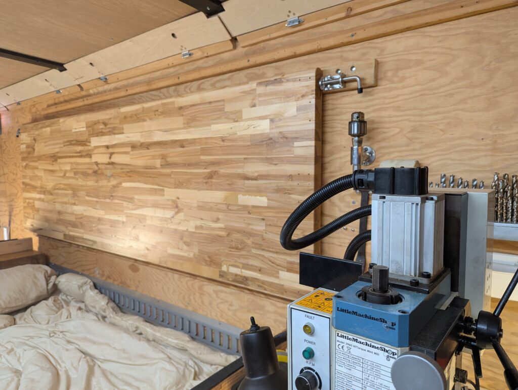 view of retracted folding workbench over the bed in mobile lab